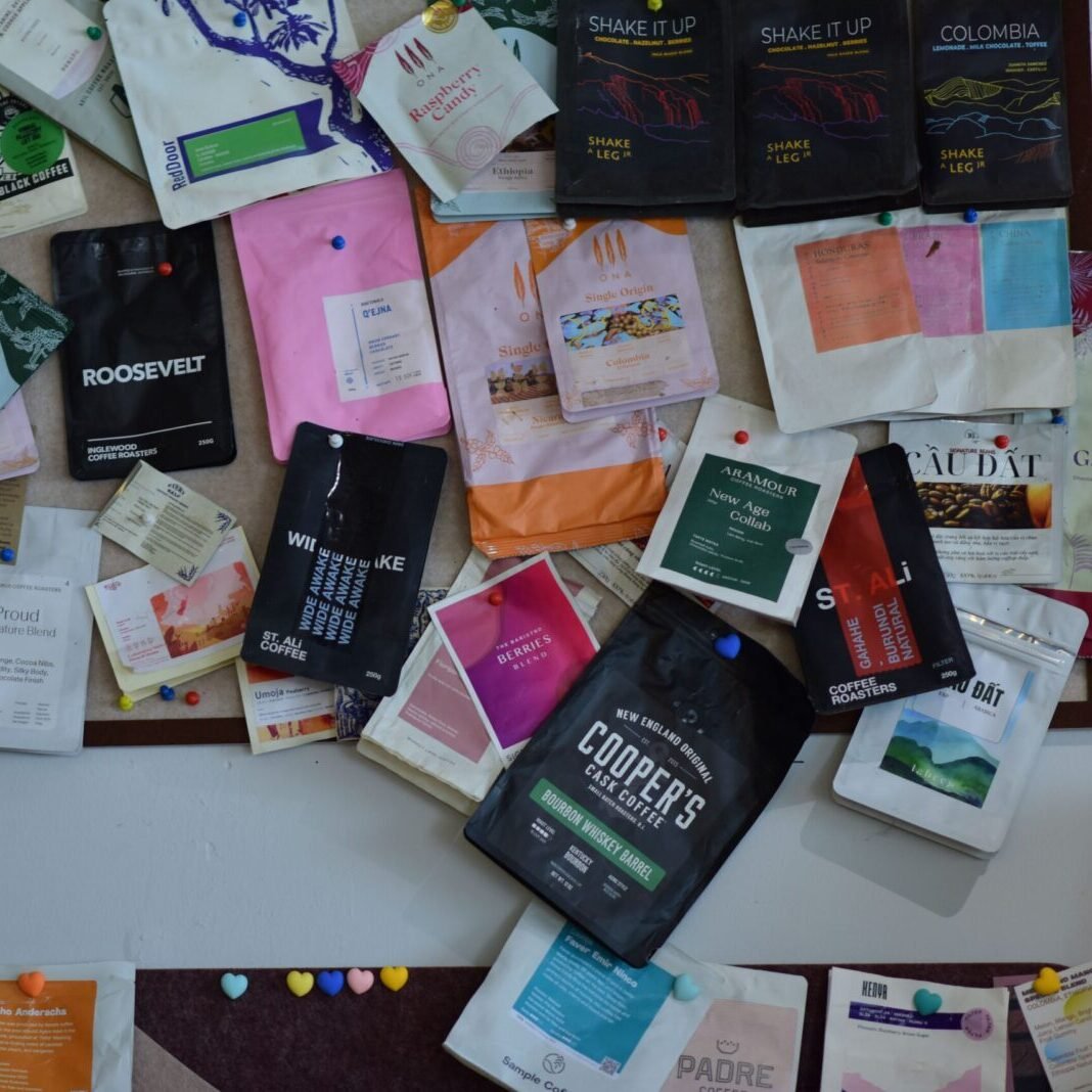 A vibrant collection of diverse coffee packaging displayed on a wall, highlighting design variety.